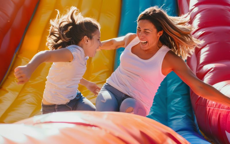 Inflatable Pillow Fight Fun: Adult Women Bring Cheer to Outdoor Amusement Park